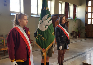 Sztandar szkoły reprezentowany przez troje uczniów podczas mszy św.