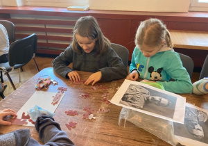 Dwie dziewczynki układają puzzle.