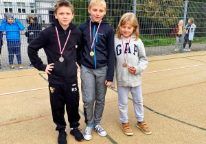 Troje uczniów nagrodzonych medalami.