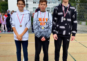 Troje uczniów z klas starszych nagrodzonych medalami.