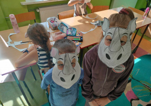 Uczniowie w maskach nosorożca, wykonanych z okazji Dnia Nosorożca.