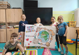 Uczniowie prezentujący pomalowaną przez siebie kolorowankę o Dniu Praw Dziecka.